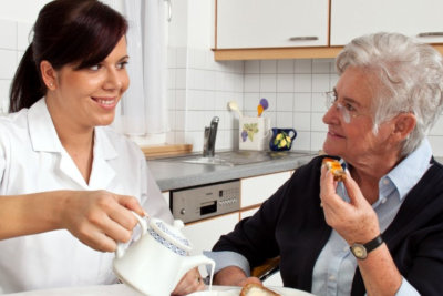 middle aged woman pouring tea for an elderly woman