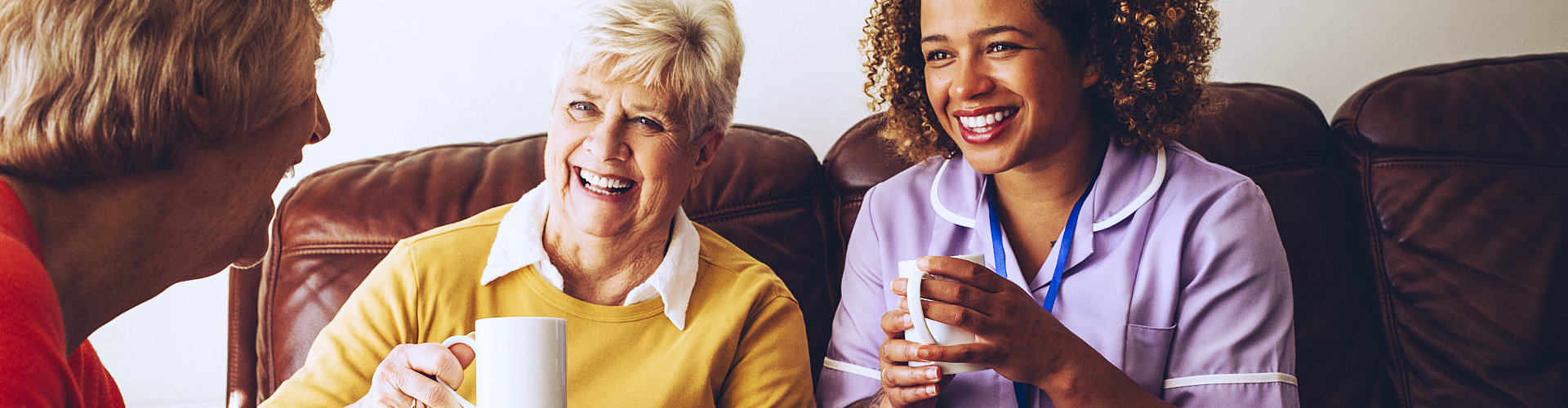 middle aged woman having a coffee with 2 elderly woman